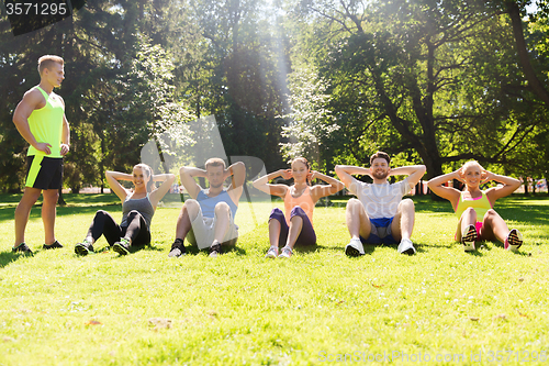 Image of group of friends or sportsmen exercising outdoors