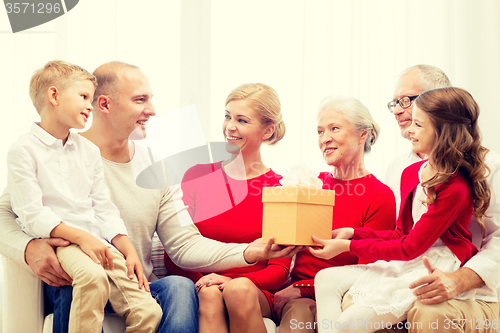 Image of smiling family with gift at home