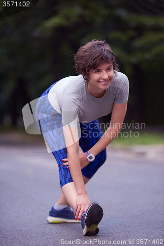 Image of woman  stretching before morning jogging