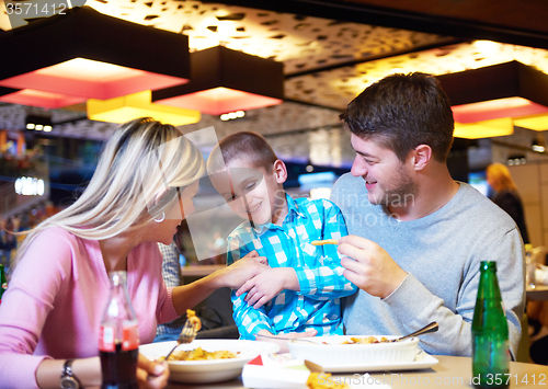 Image of family having lunch in shopping mall