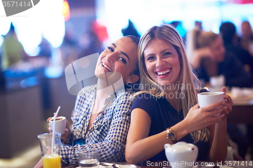Image of girls have cup of coffee in restaurant