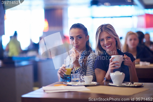 Image of girls have cup of coffee in restaurant