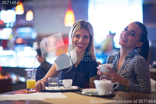 Image of girls have cup of coffee in restaurant