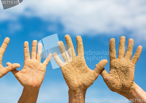 Image of Woman and Man Shows his Open Hands Covered with Beach Sand