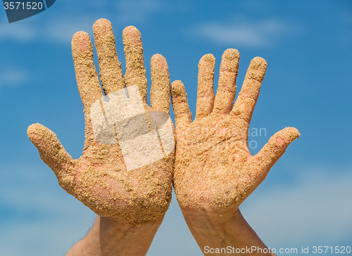 Image of Woman and Man Shows his Open Hands Covered with Beach Sand