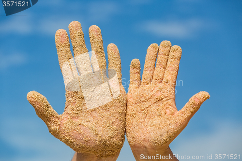 Image of Woman and Man Shows his Open Hands Covered with Beach Sand