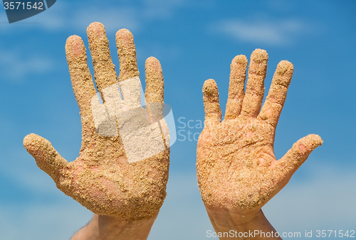 Image of Woman and Man Shows his Open Hands Covered with Beach Sand