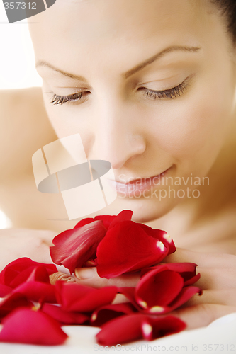 Image of young female with rose petals