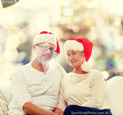 Image of happy senior couple in santa helper hats