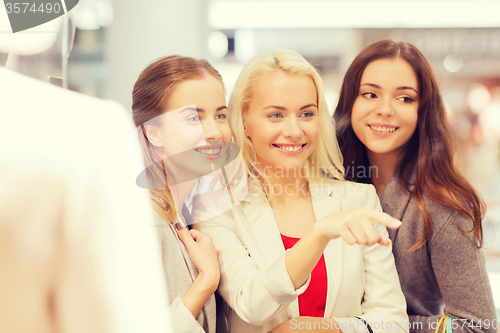 Image of happy young women with shopping bags in mall