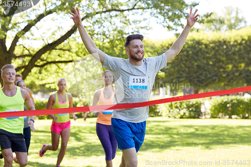 Image of happy young male runner winning on race finish