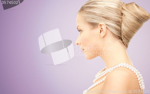 Image of beautiful woman with pearl necklace over violet