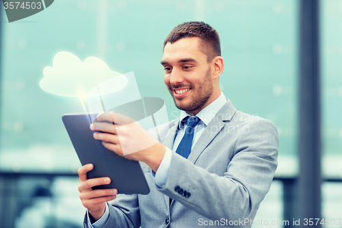 Image of smiling businessman with tablet pc outdoors