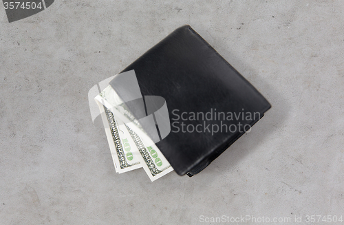 Image of close up of dollar money in black wallet on table