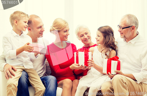 Image of smiling family with gifts at home