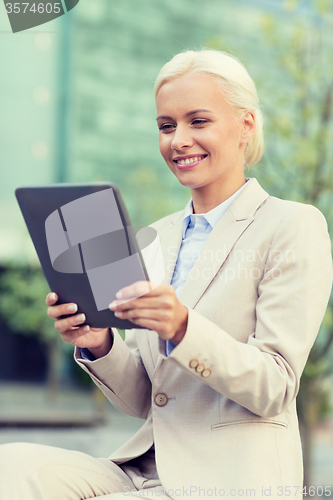 Image of smiling businesswoman with tablet pc outdoors