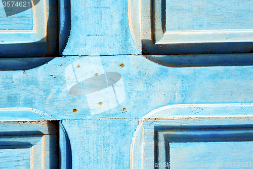 Image of dirty   in   blue wood door and rusty nail