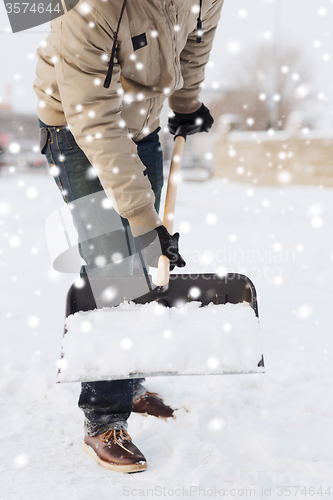 Image of closeup of man digging snow with shovel