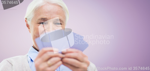 Image of close up of happy senior woman playing cards