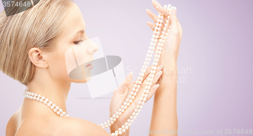 Image of beautiful woman with pearl necklace over violet