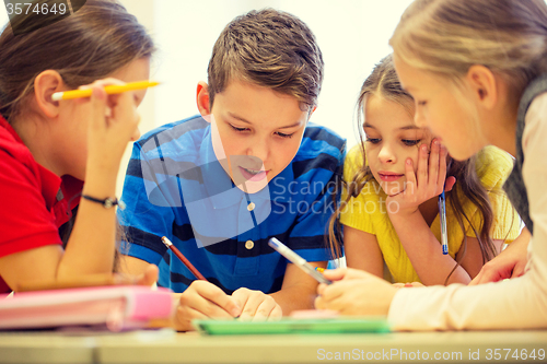 Image of group of students talking and writing at school