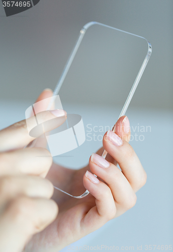 Image of close up of woman with transparent smartphone