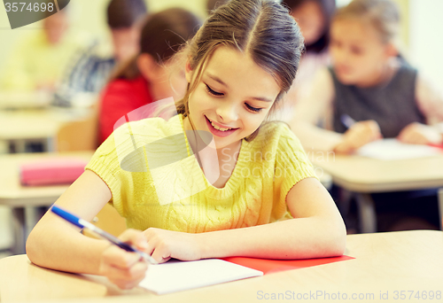 Image of group of school kids writing test in classroom