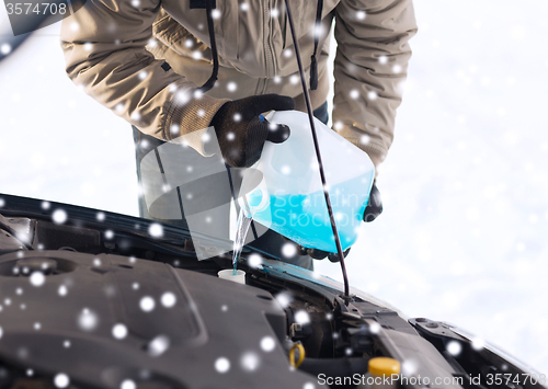 Image of closeup of man pouring antifreeze into car