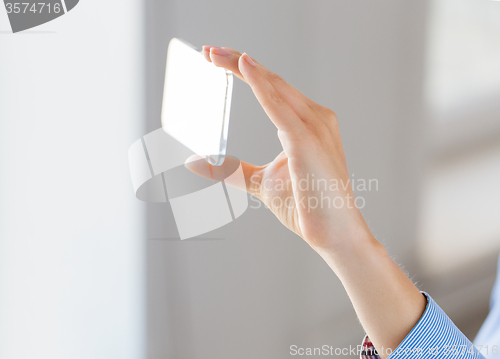 Image of close up of woman with transparent smartphone