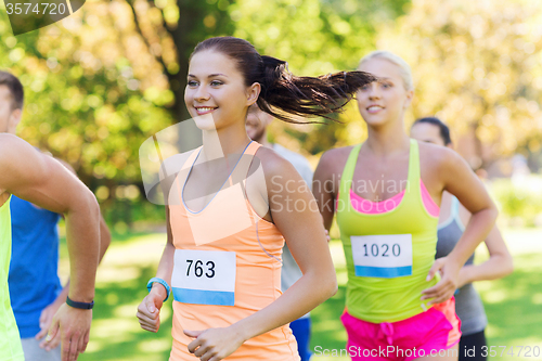 Image of happy young sportsmen racing wit badge numbers