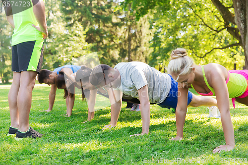 Image of group of friends or sportsmen exercising outdoors