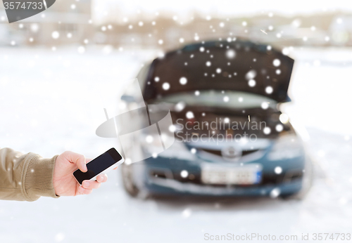 Image of closeup of man with broken car and smartphone