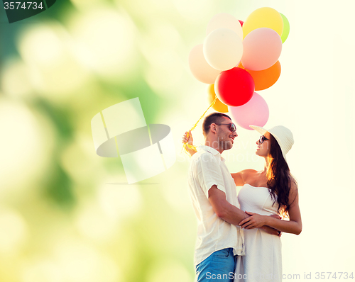 Image of smiling couple with air balloons outdoors