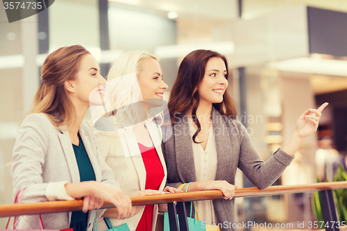 Image of happy young women with shopping bags in mall