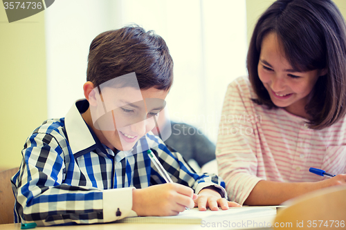 Image of group of school kids writing test in classroom