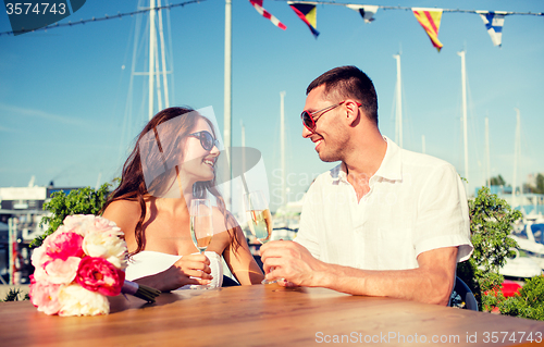 Image of smiling couple drinking champagne at cafe