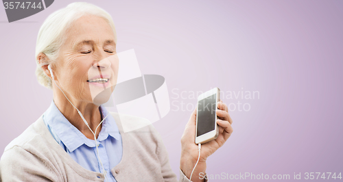 Image of senior woman with smartphone and earphones