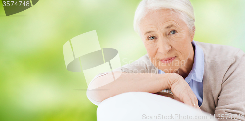 Image of happy senior woman resting on sofa