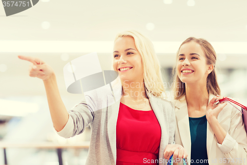 Image of happy young women with shopping bags in mall