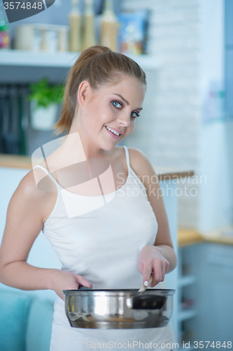 Image of Young Woman in Underwear Holding Frying Pan