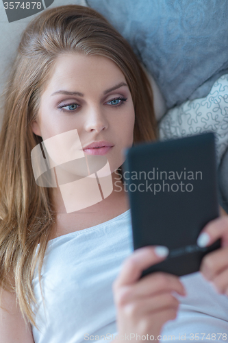 Image of Beautiful woman reading on a tablet-pc