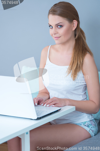 Image of Young woman working on a laptop computer