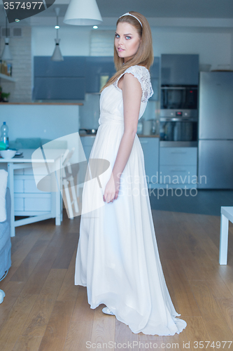 Image of Woman Wearing Wedding Dress Standing in Kitchen