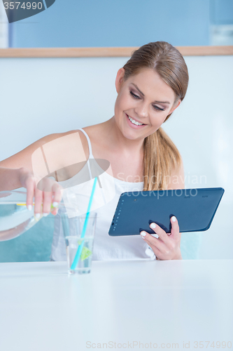 Image of Thirsty young woman pouring a glass of water