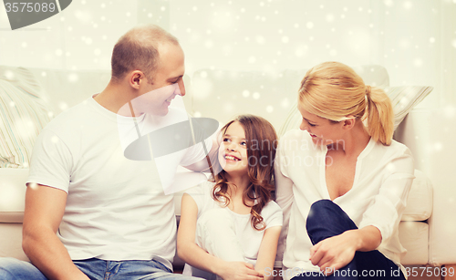 Image of parents and little girl sitting on floor at home