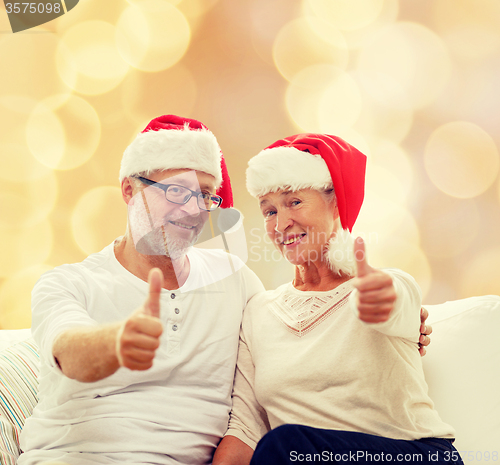 Image of happy senior couple in santa helper hats