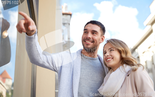 Image of happy couple shopping and looking at shop window