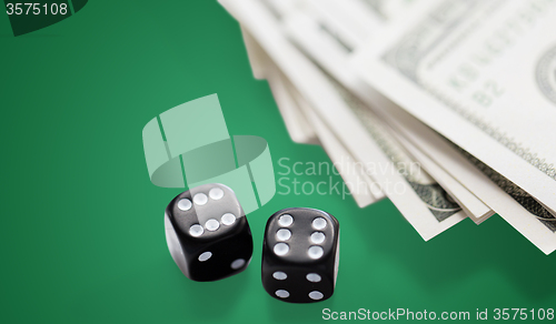 Image of close up of black dice and dollar cash money