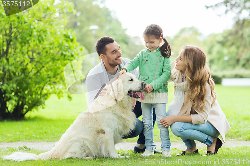 Image of happy family with labrador retriever dog in park