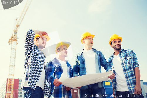 Image of group of builders with tablet pc and blueprint